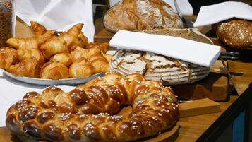 Variedad de panes y pasteles sobre una mesa de madera.
