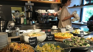 Un buffet con diversi piatti, come insalata di finocchi, insalata di broccoli e insalata di quinoa.
