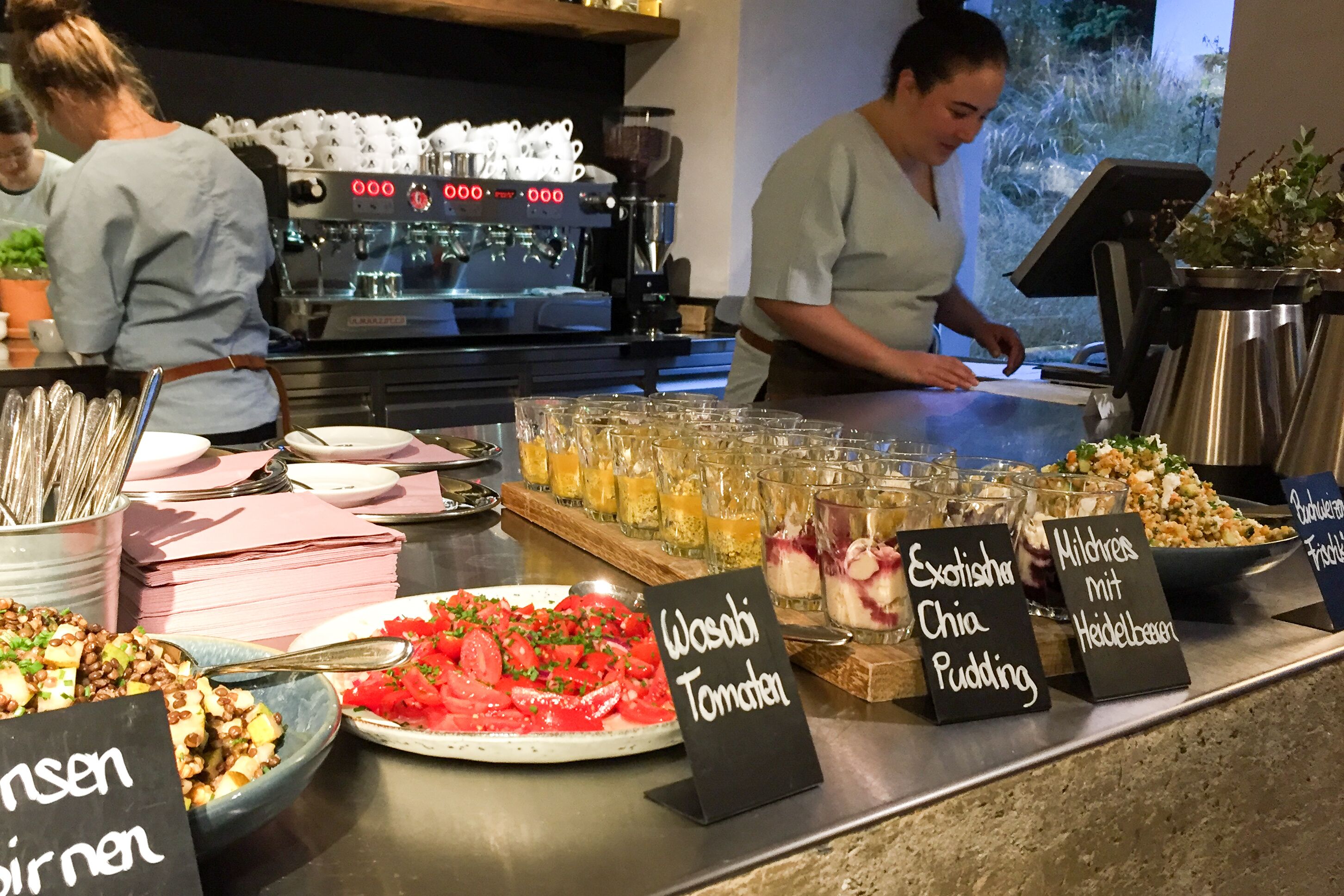Un'area buffet con diverse opzioni di cibo e una macchina per il caffè sullo sfondo.