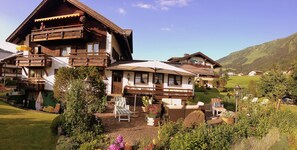 Un bâtiment de style chalet doté d’un balcon, d’un espace extérieur aménagé et d’un jardin.