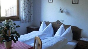 A single bed with white linens, a wooden headboard, and a bedside table with a lamp. - Kolberhof Gasthof (ALPBACH)