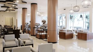 A hotel lobby with seating areas, a reception desk, and large windows. - Palu Golden (Palu)