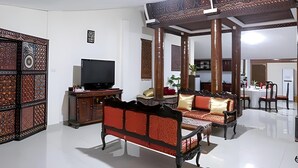 A spacious living room with a sofa, television, and decorative panels. - Toraja Misiliana (Rinding Batu)
