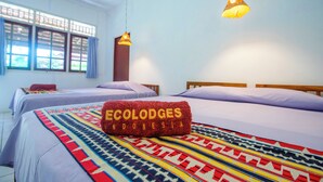 A hotel room with two beds, a patterned bedspread, and a towel with "Ecolodges Indonesia" text. - The Satwa Elephant Ecolodge (Labuhan Ratu)