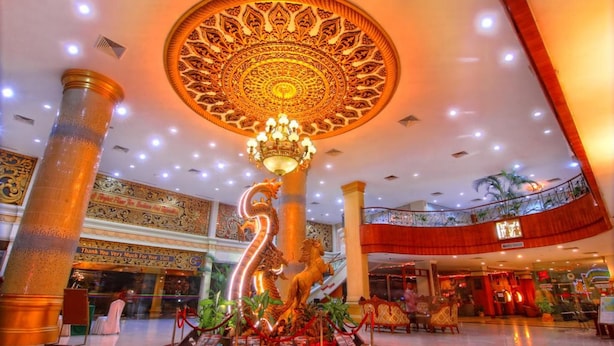 A spacious lobby with a large, ornate chandelier, a central decorative column, and a dragon sculpture.