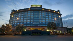 A large, multi-story hotel with a central atrium and a covered entrance.