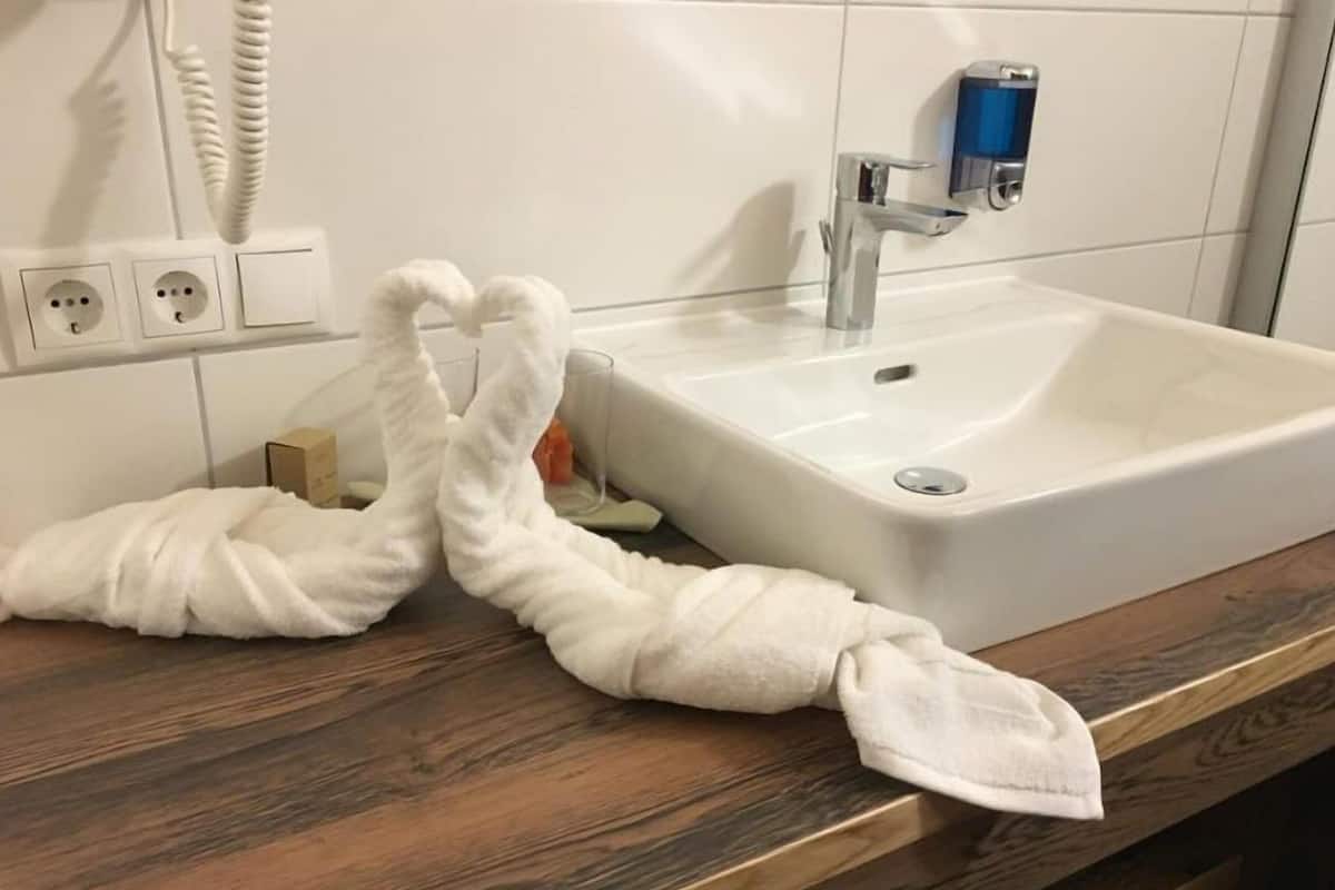 A bathroom with a white sink, a mirror, and a towel rack.
