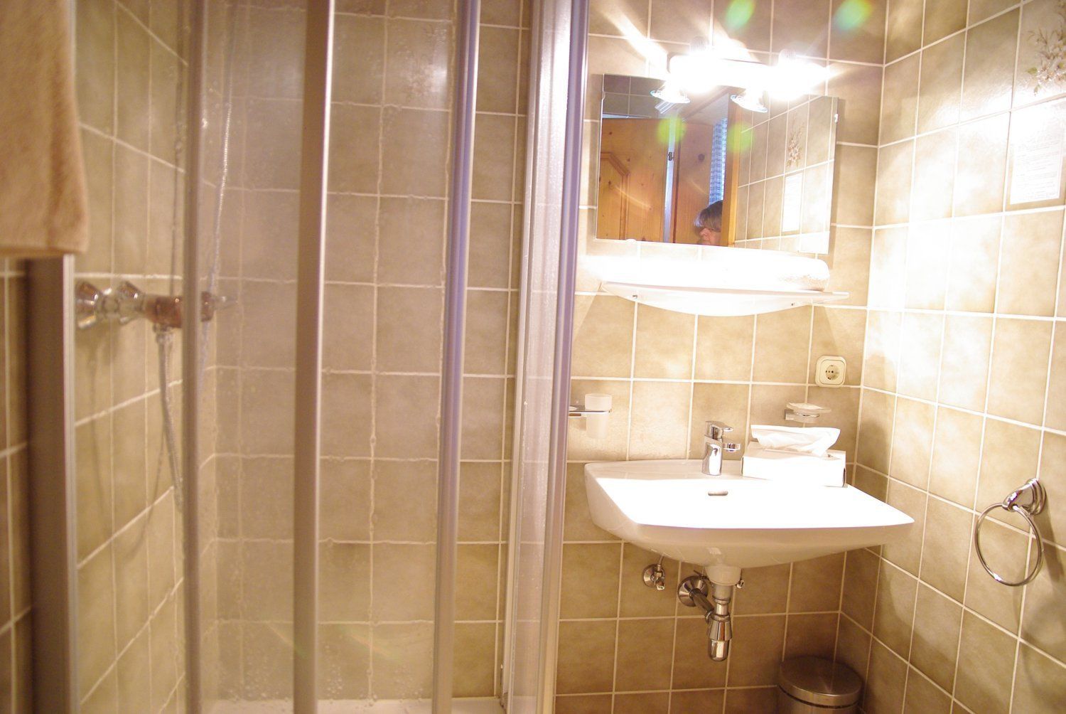 Ein Badezimmer mit Dusche, Waschbecken und Spiegel.