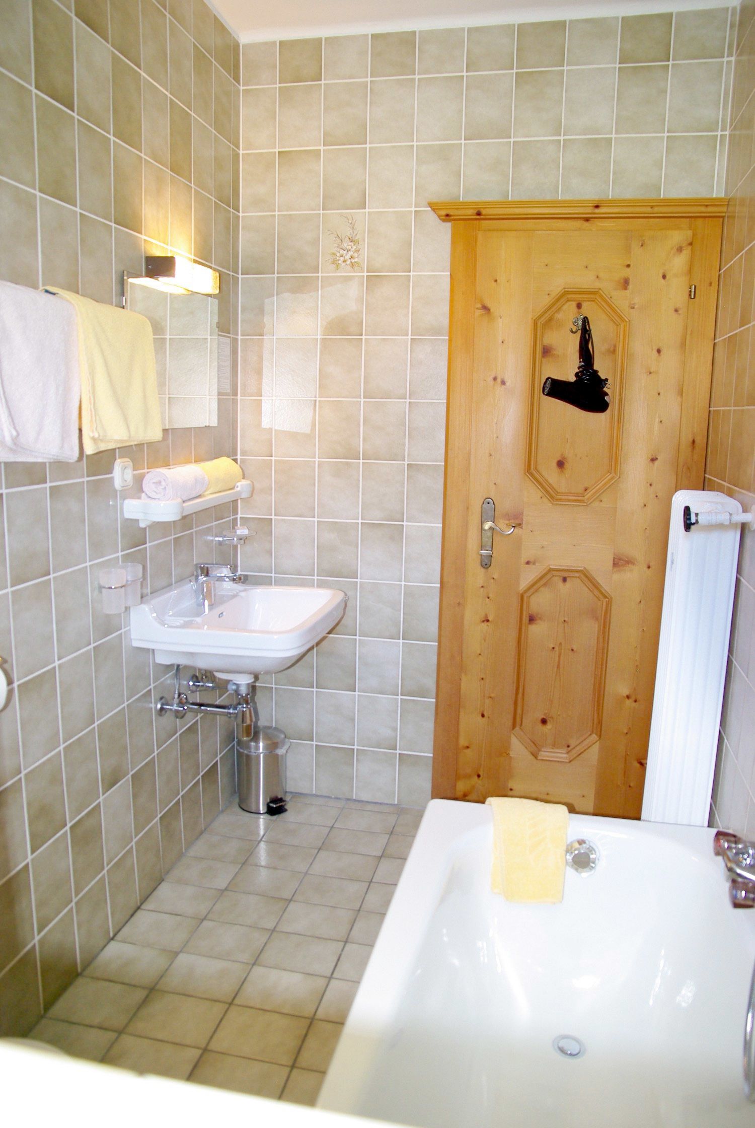Une salle de bain avec un lavabo, une baignoire et une porte en bois.