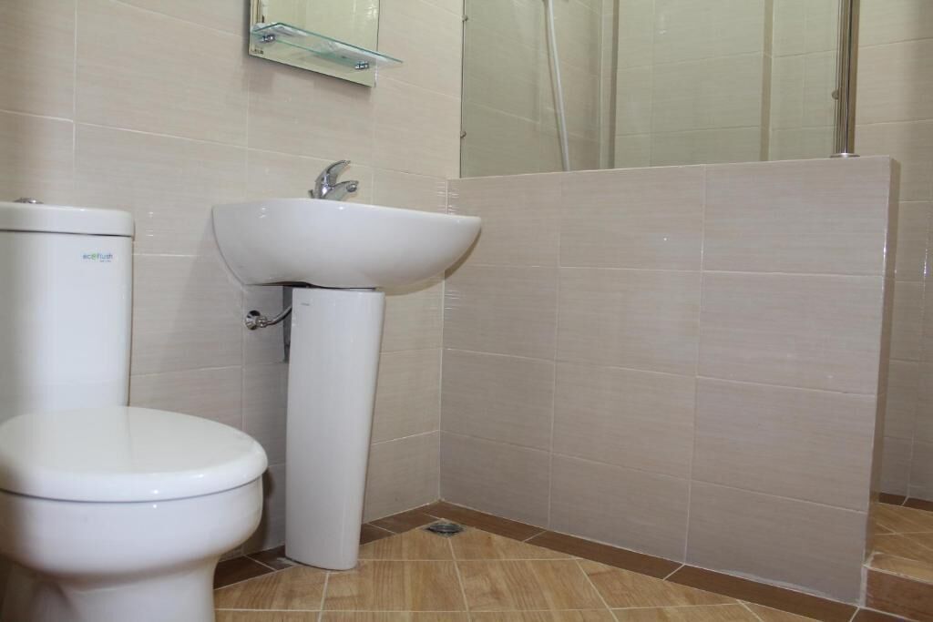 A bathroom with a toilet, sink, and shower area.