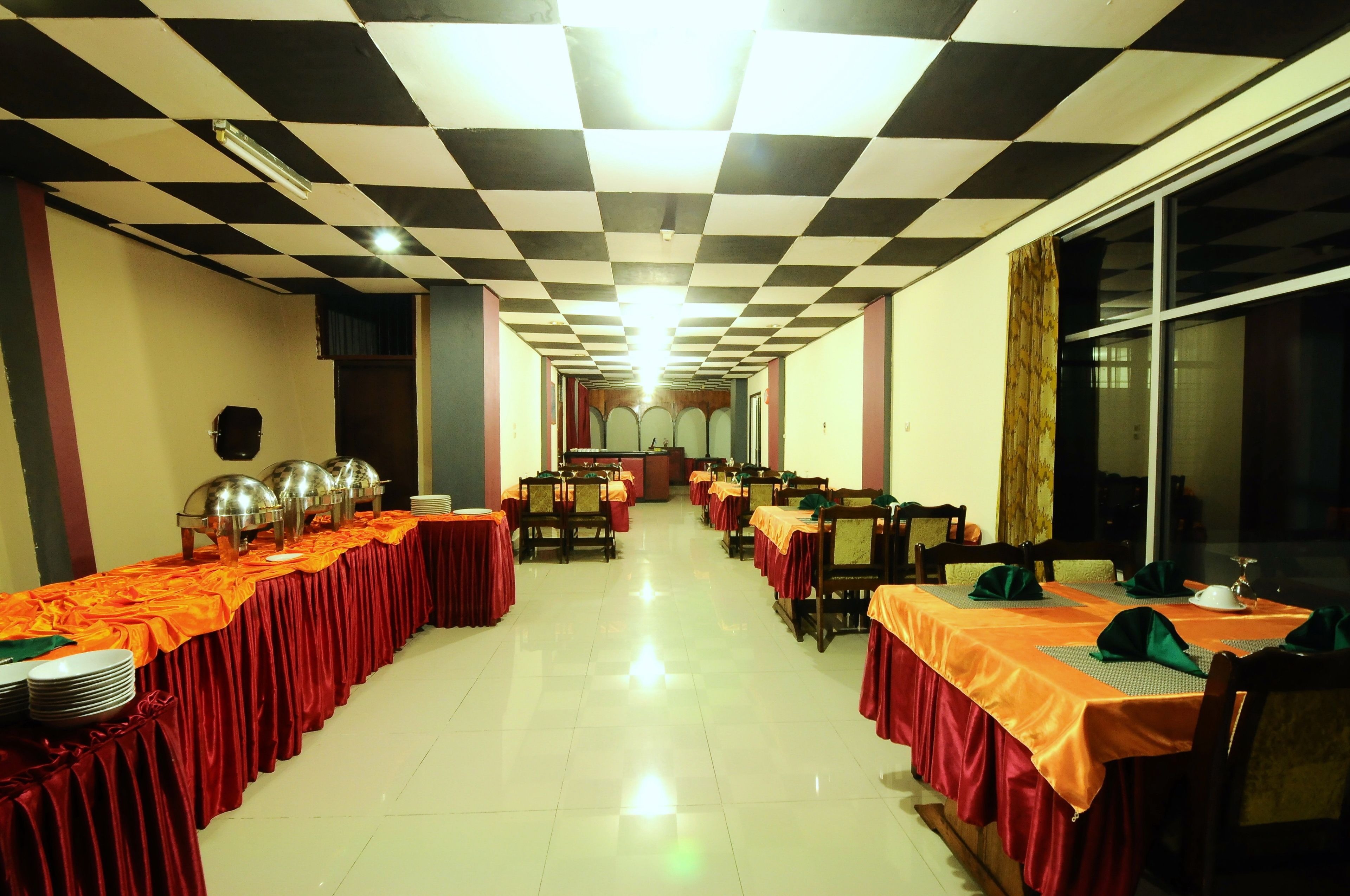 A banquet hall with long tables, chairs, and buffet stations.
