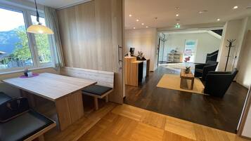 Un hall d’hôtel moderne avec un comptoir d’accueil en bois, un espace salon et une vue sur l’extérieur.