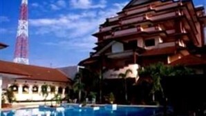 Un hôtel doté d’une piscine, d’une haute tour et d’un immeuble à plusieurs étages avec des balcons.
