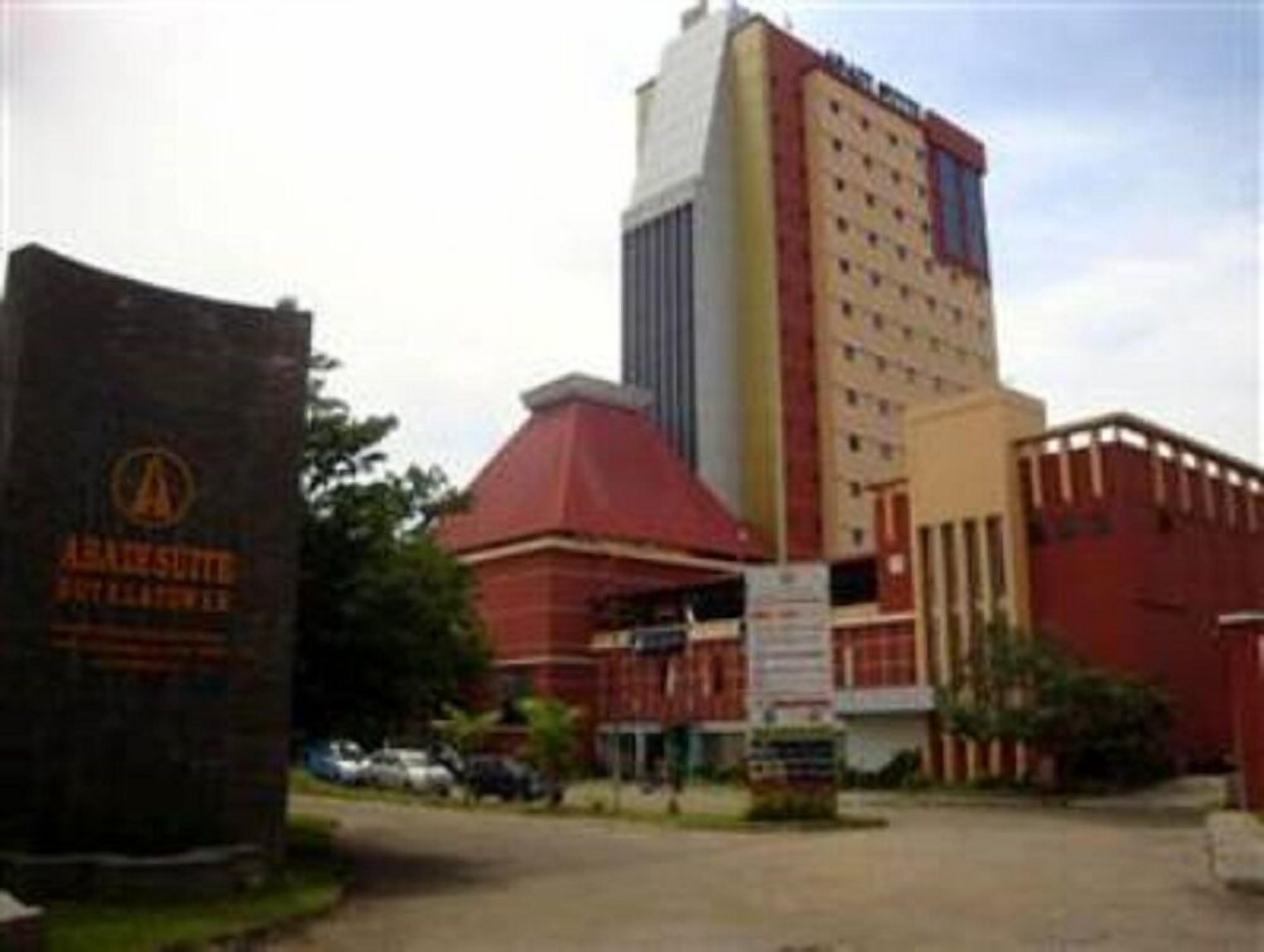 A hotel with a prominent red building and a tall structure with a white facade.