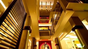 Un intérieur moderne avec un élément central circulaire, plusieurs niveaux et un escalier.