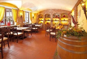 A restaurant with brick walls, wooden tables, and chairs.