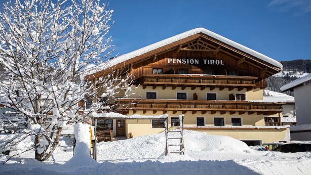 A wooden building with a sign reading "Pension Tirol" surrounded by snow. - Pension Tirol (Nauders)
