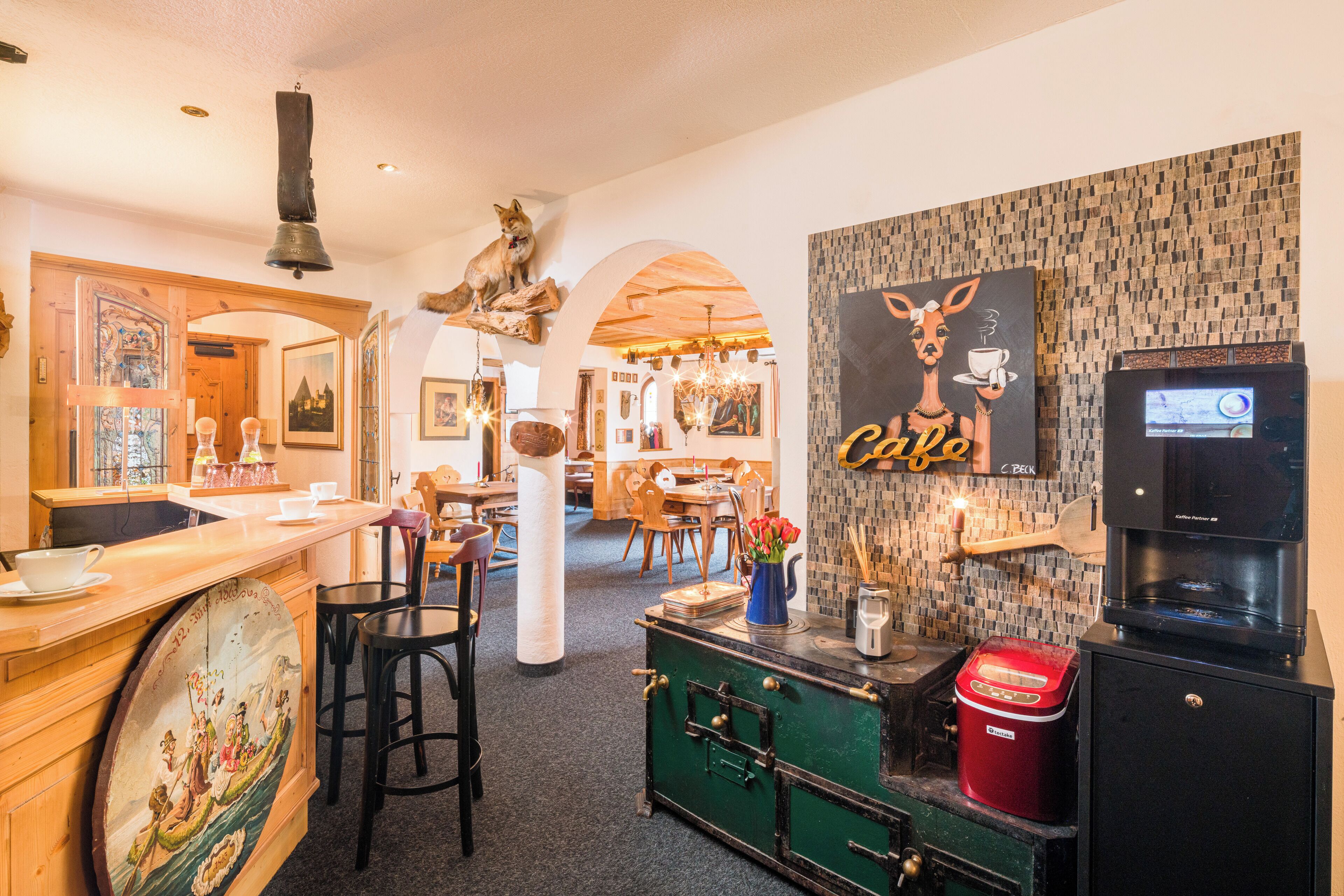 Un restaurante acogedor con decoración de madera, una máquina de café y un mural de una jirafa.