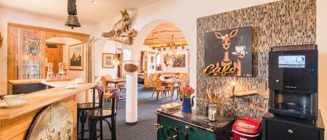 Un restaurante acogedor con decoración de madera, una máquina de café y un mural de una jirafa.