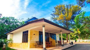 A two-story house with a covered porch, a tiled patio, and a view of surrounding trees. - Tanjung Pesona Beach Resort and Spa (Sungai Liat)