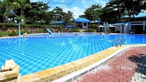 A swimming pool with a checkered pattern, surrounded by a paved walkway and greenery. - Tanjung Pesona Beach Resort and Spa (Sungai Liat)
