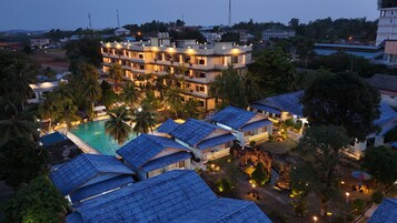 Un hotel de varios pisos con piscina y varias habitaciones.