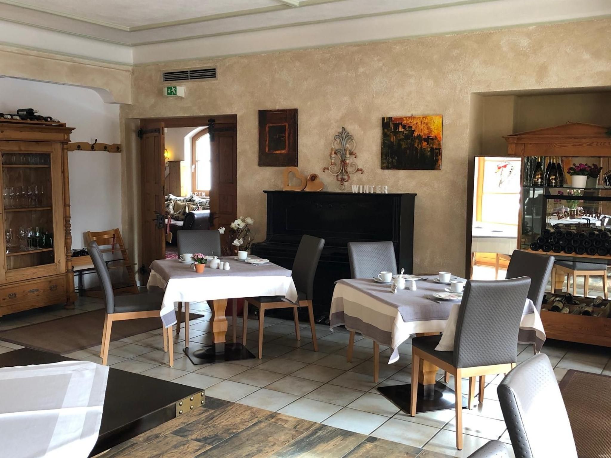 Un coin repas avec deux tables dressées pour les repas, une cheminée et un meuble à vin.