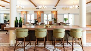A spacious kitchen with a large island, bar stools, and a chandelier. - Eden Inn (Zikhron Ya'aqov)