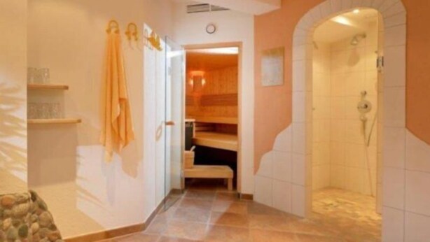 A bathroom with a shower, a toilet, and a sink. - Holiday (Ellmau)