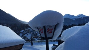 Een met sneeuw bedekte bord met de tekst 'Stiegl' in een bergachtig gebied.