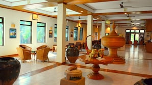 Eine großzügige Lobby mit großen Fenstern, Korbmöbeln und traditioneller Dekoration.