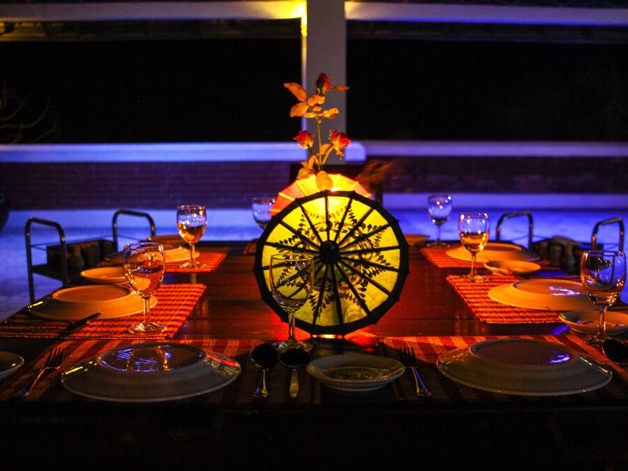 A dining table set for four with a decorative centerpiece, glasses, and cutlery.