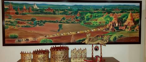 Una pintura de un paisaje con templos y un carro dorado.