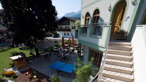 A courtyard with outdoor seating, a play area, and a staircase leading to an upper level. - Hotel Obermair (Fieberbrunn)