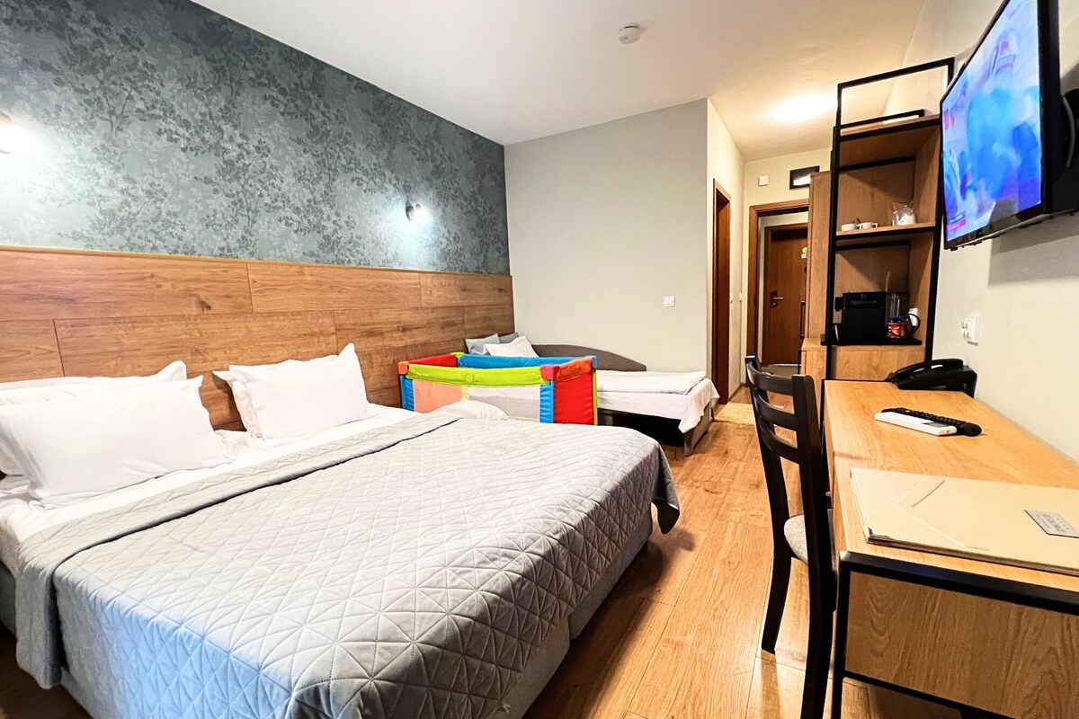 Une chambre d’hôtel équipée d’un lit, d’un bureau, d’une chaise, d’une télévision et d’une armoire.