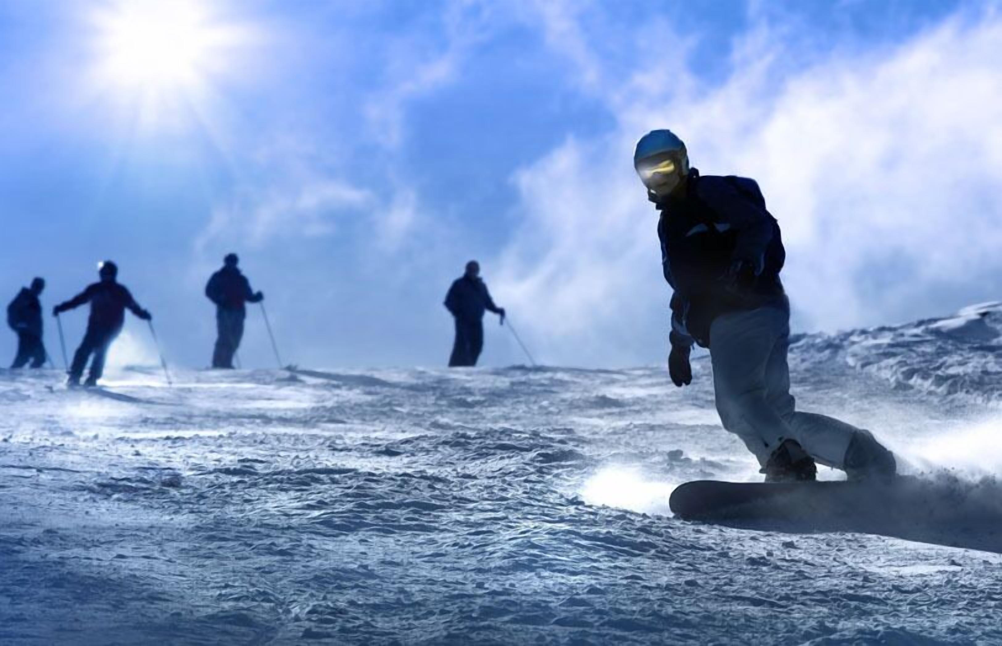 En person på snowboard på en snedækket skråning.