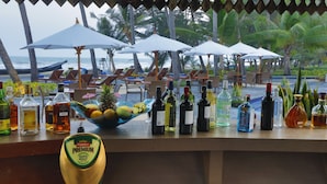 Un bar con varias botellas de alcohol y un bol de fruta.