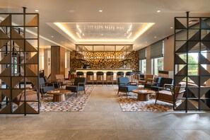 A modern lobby with a bar area, seating, and a patterned floor. - Four Points by Sheraton Bansko (Bansko)