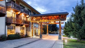 A hotel entrance with a covered outdoor area, stone pillars, and a sign reading "FOUR POINTS." - Four Points by Sheraton Bansko (Bansko)