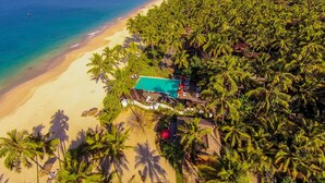 An aerial view of a beach resort with a swimming pool surrounded by palm trees and a sandy beach. - Amara Ocean Resort (Thandwe)