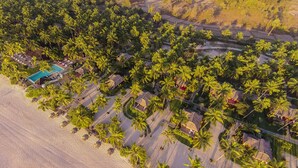 An aerial view of a resort with a swimming pool, beach, and palm trees. - Amara Ocean Resort (Thandwe)