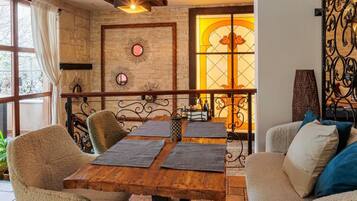 Un rincón comedor acogedor con una mesa de madera, dos sillas y una pared decorativa con un motivo de sol.