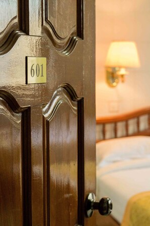 A wooden door with a brass handle and a brass plate with the number 601. - May Shan Hotel (Yangon)