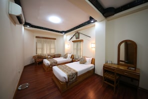 A hotel room with two beds, a wooden desk, a chair, and a mirror. - Olympic Hotel (Yangon)