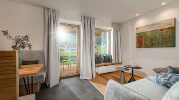Deluxe appartement, 1 slaapkamer, balkon | Woonruimte | Een flatscreentelevisie en vloerverwarming