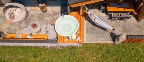 En tagterrasse med jacuzzi, hængekøje og træterrasse.