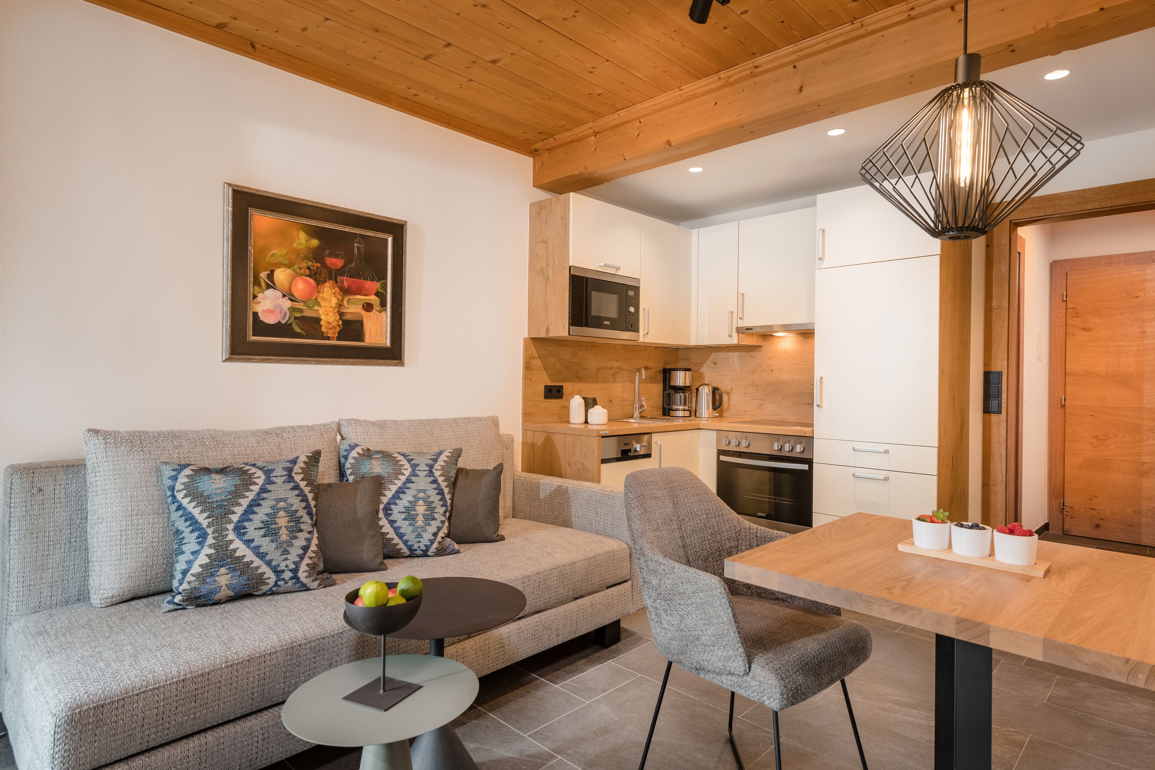 Ein modernes Wohnzimmer mit Sofa, Couchtisch und einem Essbereich mit Tisch und Stühlen.