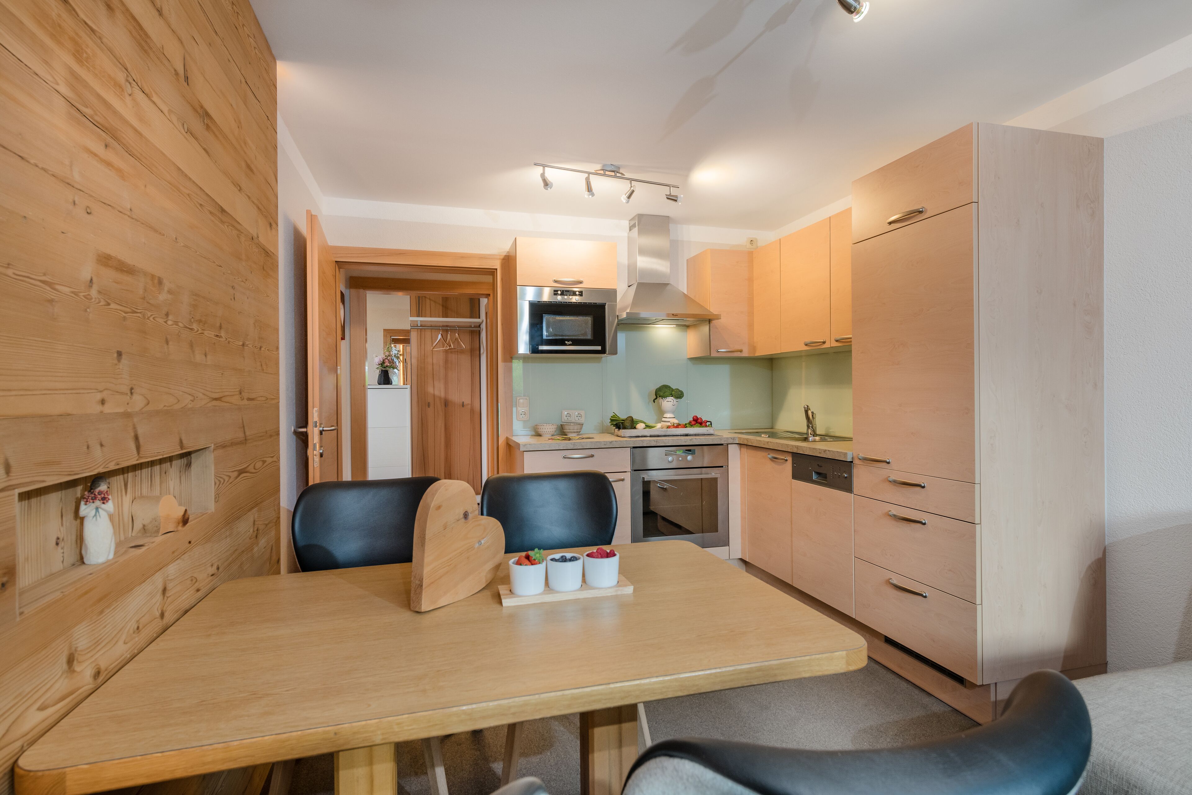 A compact kitchen with wooden cabinets, a microwave, oven, and a dishwasher.