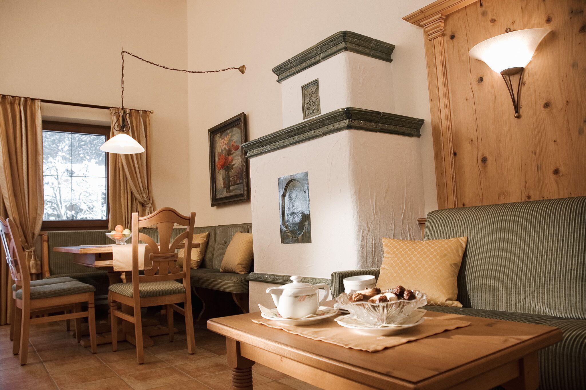 A cozy room with a dining table, chairs, a sofa, and a wall-mounted light fixture.