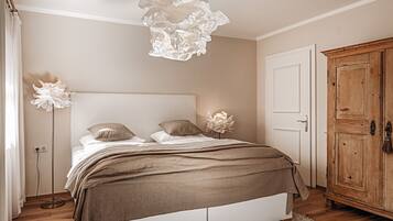 A bedroom with a bed, bedside lamps, a wardrobe, and a floor lamp.
